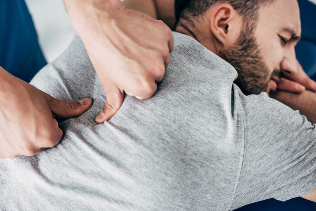 Patient discusses back pain with a chiropractor during a calm, professional examination.
