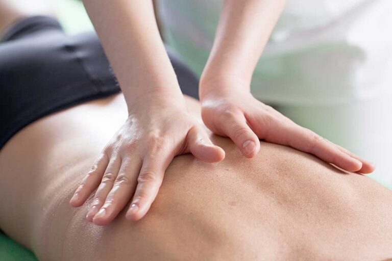 Pregnant woman lying supported on her side while receiving a gentle back adjustment